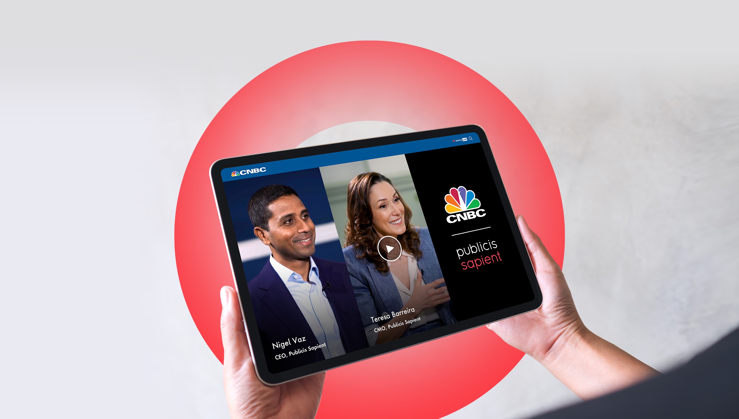 A person holding a tablet that shows a split video screen. CEO Nigel Vaz is on the left and logos for CNBC and Publicis Sapient are on the right.