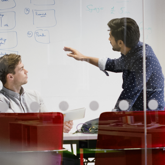 partners collaborating on white board in meeting room