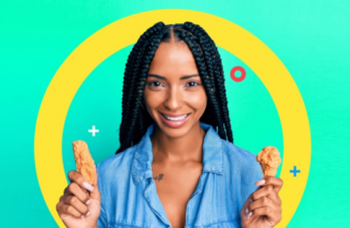 person holding chicken wings in each hand and smiling