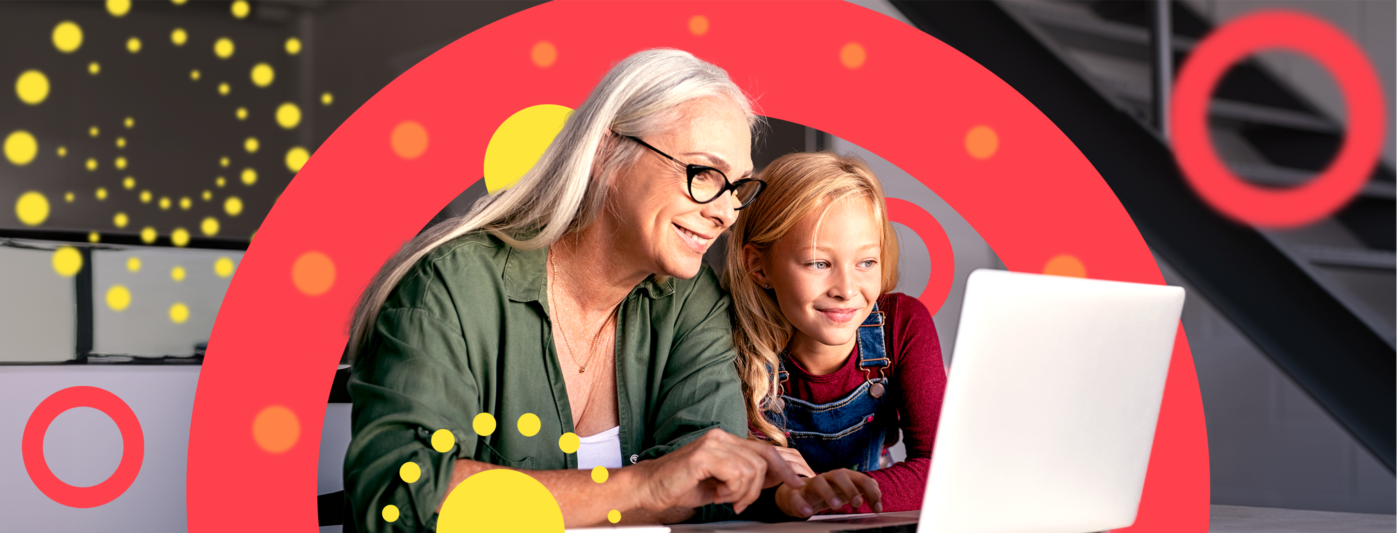 An elderly woman and a young girl looking at a laptop, smiling