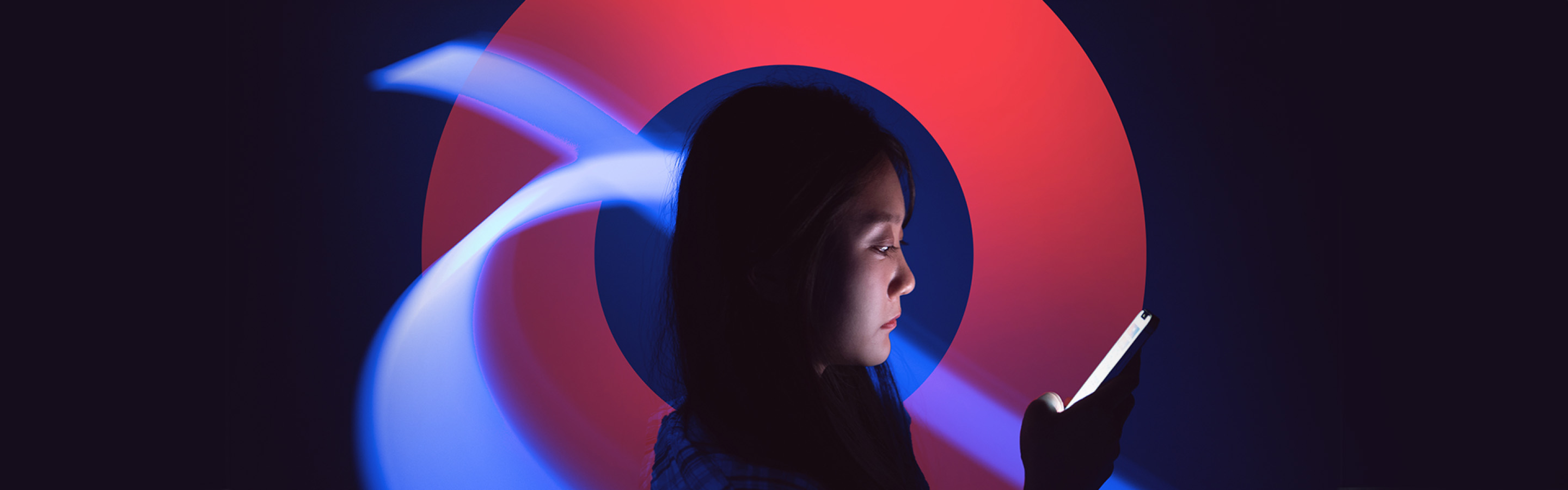 Woman looking at smart phone with a light sweeping around her